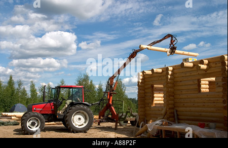 Trattore Valmet che solleva un nuovo balk alla parete finlandese della cabina di tronchi, Finlandia Foto Stock
