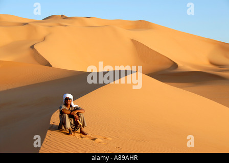 Il tuareg si siede su un sanddune nel deserto Mandara Libia Foto Stock