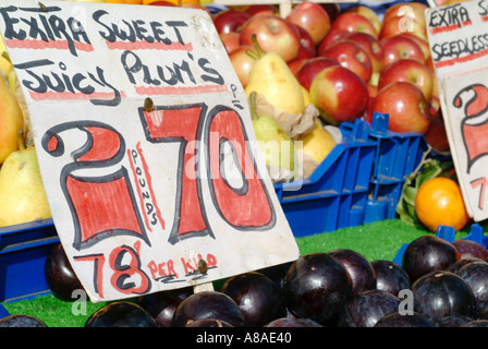 La frutta e le verdure sul mercato succosa di stallo prugne trader capitalismo capitalista denaro commercio libero commercio di mercato Foto Stock