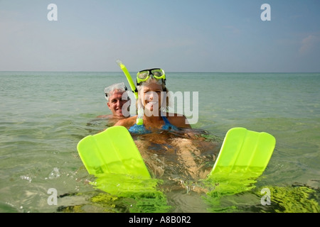 Giovane giocando in chiaro di acqua oceanica indossare pinne verde e snorkeling. Foto Stock