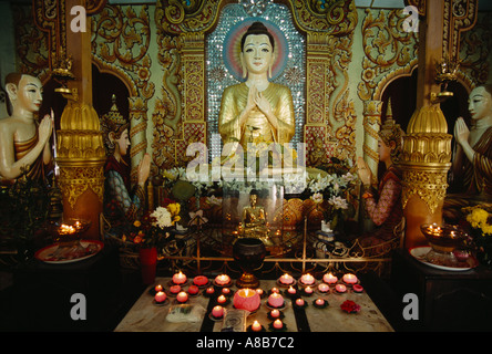 MALAYSIA Penang Island Georgetown Dharmikarama Tempio birmano candele illuminazione seduto grande statua del Buddha e piccoli di quelli d'oro. Foto Stock