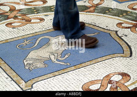 L'uomo la filatura su tori testicoli per buona fortuna in Galleria Vittorio Emmanuelle, Milano, Italia Foto Stock