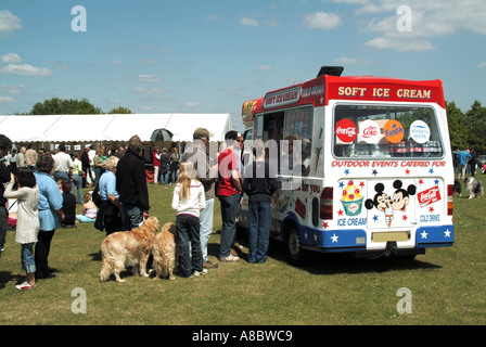 Dog show in un giorno di estate persone in piedi & accodamento in ice cream van alcuni con i loro cani tutti in attesa di acquisto di gelato o bevande Essex REGNO UNITO Foto Stock