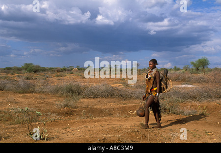 Hamer Donna che cammina nel deserto semi , Turmi , a sud della valle dell'Omo , Etiopia Foto Stock