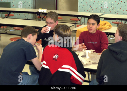 Gli studenti di bere cioccolata calda e mangiare cruellers età 14. Golden Valley Minnesota USA Foto Stock