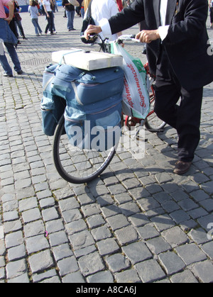 Uomo che porta il carico pesante sulla spinta bike a roma Foto Stock