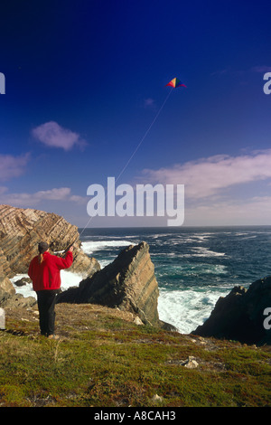 Donna aquilone volante sulle scogliere che si affacciano sull'oceano Canada Foto Stock