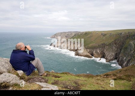 Regno Unito Lundy Island Oceano Atlantico costa mezza età walker guardando gli uccelli attraverso il binocolo Foto Stock
