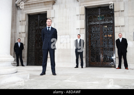 Quattro uomini d'affari 4 che pongono in Leeds Millennium Square per un servizio fotografico commerciale Foto Stock