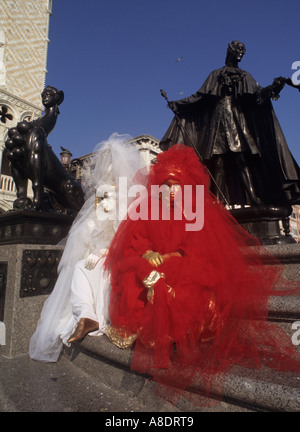 La scultura di Casanova e maschere di carnevale seduti sui gradini a Venezia Italia Foto Stock