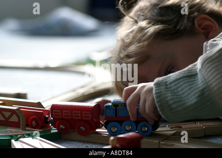 Lewis di tre anni giocando con il suo prezioso convoglio in legno Foto Stock