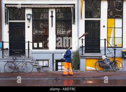 Uomo passato a piedi Biciclette e case colorate Foto Stock