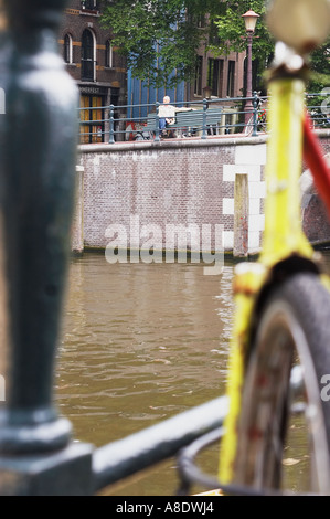 Uomo seduto su un banco di lavoro con la bicicletta in primo piano Foto Stock