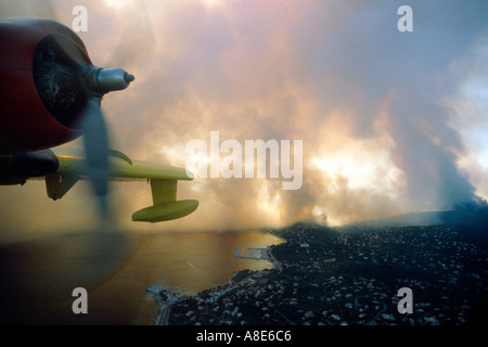 Canadair antincendio bombardiere acqua aereo motore, vista aerea, Sainte-Maxime bay, wildfire fumo in distanza, crepuscolo, Provenza, Francia, Europa Foto Stock