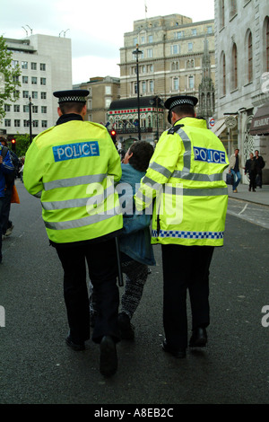 Giorno di maggio due funzionari di polizia di trattenere un manifestante Londra Foto Stock