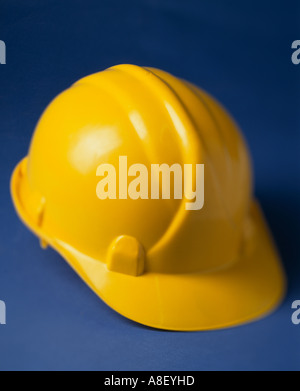 Casco giallo casco di sicurezza su sfondo blu Foto Stock