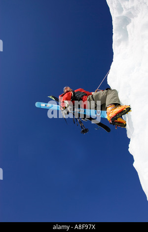 Maschio Ice Climber Ice climbing faccia con gli sci in zaino Foto Stock