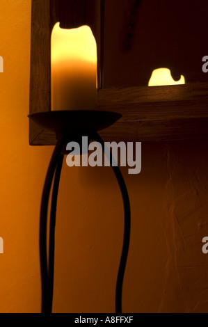 Candela ambra accanto al grande specchio in legno Foto Stock