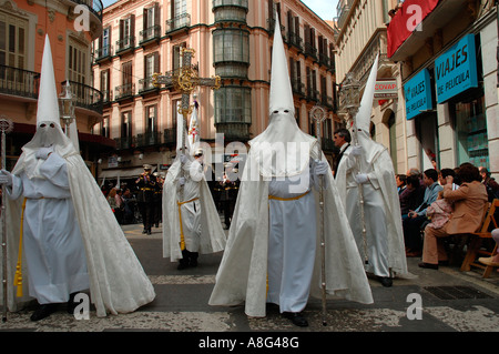 Bianco uomini incappucciati nella Domenica di Pasqua processione, Malaga, Spagna Foto Stock