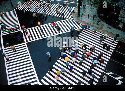 Persone con ombrelloni su attraversamento pedonale in intersezione, Ginza, Tokyo, Giappone Foto Stock