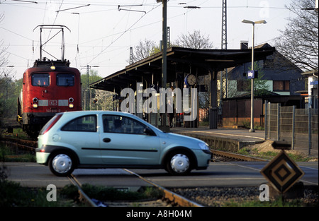 Auto criossing un passaggio a livello ferroviario di fronte a un treno in avvicinamento, Leichlingen, Renania settentrionale-Vestfalia (Germania). Foto Stock
