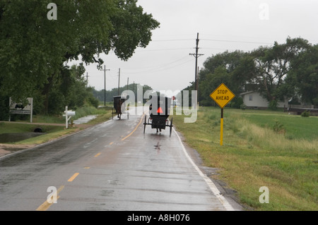 Carrelli Amish sulla pioggia strada Slicked Yoder Kansas Foto Stock