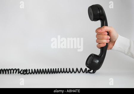 Mano che tiene il ricevitore del telefono Foto Stock