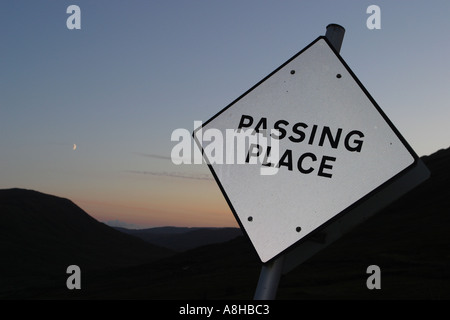 Passando place road sign in una posizione remota nel mezzo delle Highlands scozzesi al tramonto tramonto Foto Stock