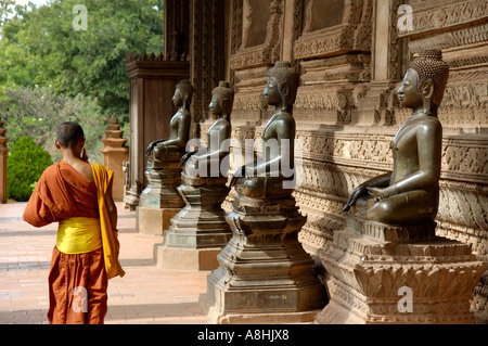 Giovane monaco passeggiate lungo vecchie statue di Buddha tempio Haw Pha Kaew Vientiane Laos Foto Stock