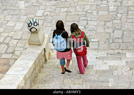 I bambini della scuola con zaino in spalla andando giù per le scale, due amici, Graffiti, Alicante, Spagna Foto Stock