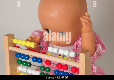 Aritmetica di apprendimento, la bambola usando un abaco Foto Stock