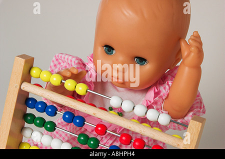 Aritmetica di apprendimento, la bambola usando un abaco Foto Stock