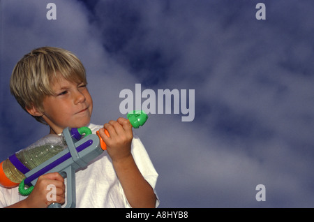 Ragazzo con pistola ad acqua pronto a far fuoco e circa a scopo Foto Stock