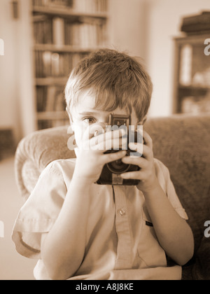 Seppia Immagine di bambino in maglia grigia di scattare una foto con la vecchia telecamera bakerlite Foto Stock