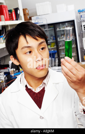 Close-up di un farmacista maschio guardando un tubo di prova Foto Stock