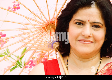 Close-up di una donna matura tenendo un ombrellone Foto Stock