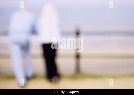 Impressionistica vista posteriore di un uomo e di una donna in luce i vestiti estivi appoggiata sulle ringhiere e guardando il mare Foto Stock
