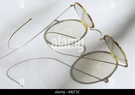 Un paio di occhiali con lenti circolari e tartaruga sottili cornici e bracci di filo di colata di una grande ombra intricati Foto Stock