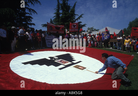 Un UFW marcher luoghi immagini di Cesar Chavez e la Vergine di Guadalupe in un gigante Regno i lavoratori agricoli bandiera. Foto Stock