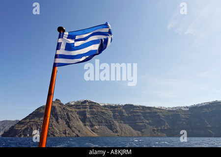 Bandiera Greca e sullo sfondo la caldera, Santorini, Grecia Foto Stock
