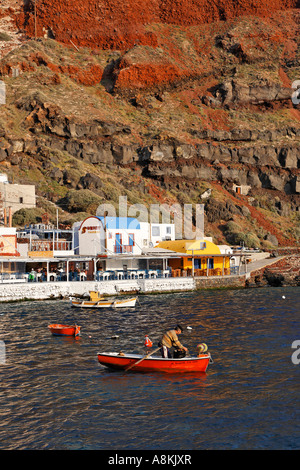 Un pescatori nella sua piccola barca a remi, porto di Ammoudi, Oia - Santorini, Grecia Foto Stock