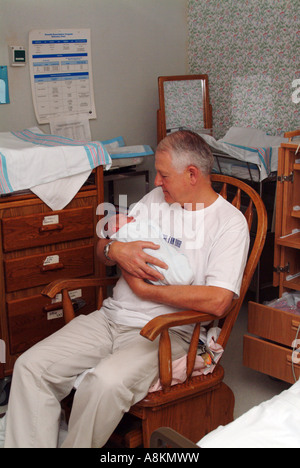 Emozionato nonno tiene il suo nipote per la prima volta nella camera di mandata. Foto Stock