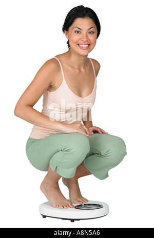 Una donna del peso di se stessa su una scala Foto Stock