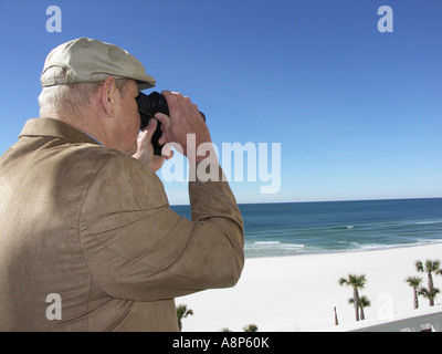 Guardando attraverso il binocolo in spiaggia vuota Foto Stock