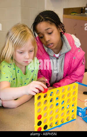 Le ragazze la riproduzione di collegare quattro checker verticale gioco. Dopo la scuola programma di studio. St Paul Minnesota USA Foto Stock