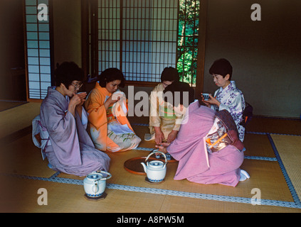 Donne che indossano kimono seduto in casa da tè in Tokyo, Giappone Foto Stock