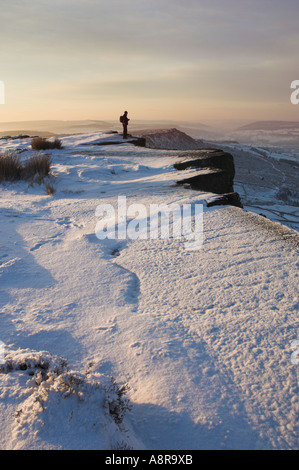 Escursionista nella neve la mattina presto sul bordo Froggatt Derbyshire parco nazionale di Peak District Calver England Regno Unito GB EU Europe Foto Stock