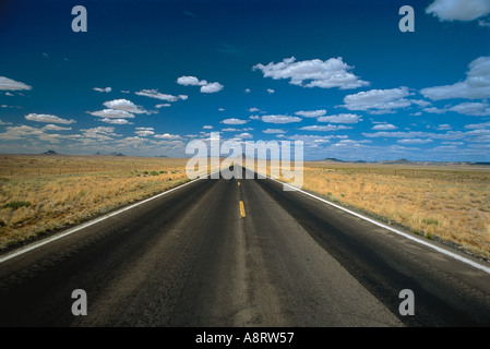 Immediatamente in vista di una autostrada deserta in distanza su un poco nuvoloso giorno soleggiato Foto Stock