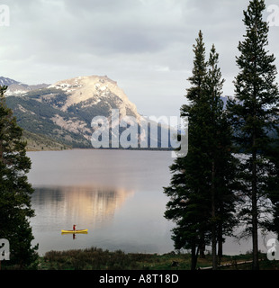 Canoa pescatore in acque tranquille del fiume Verde i laghi di Wind River Mountain range del Wyoming Foto Stock