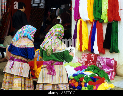 Due fiori donne Hmong guardando intensamente policrome presso il mercato della domenica, Bac Ha, NW Viet Nam Foto Stock